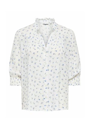 Blouse blanche boutonnée avec imprimé floral bleu, col volanté et manches trois-quarts bouffantes avec poignets froncés.
