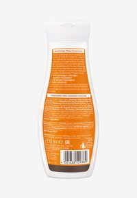 Vit flaska med en böjd form och flip-top lock. Orange och vit etikett detaljerar ingredienser, fördelar och bruksanvisning. 200 ml storlek.