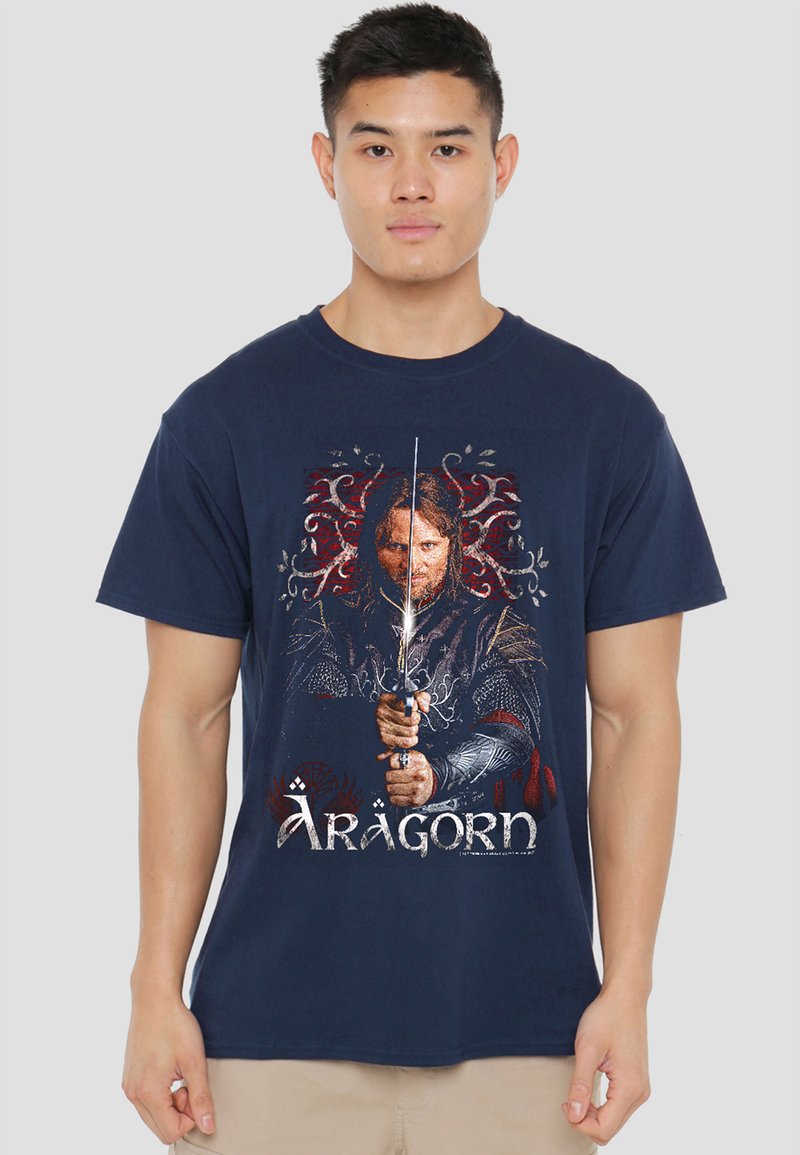 Young man wearing a navy blue t-shirt featuring a graphic of a medieval warrior holding a sword and the text "Aragorn" below.