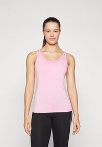 Rosa ermeløs tank-top i et glatt, lett stoff med rund hals og en tettsittende silhuett, parret med svarte leggings.