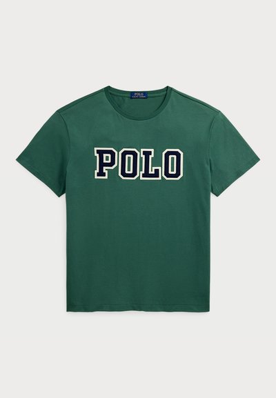Groene katoenen T-shirt met een ronde hals en korte mouwen. "POLO" logo in vet marineblauwe letters op de borst. Zachte textuur.
