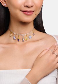 Silberne Ketten-Halsband mit mehreren Anhängern, darunter: lila Herz, Pfotenabdruck und Eistüte, mit goldenen Akzenten und einzigartigen Designs.
