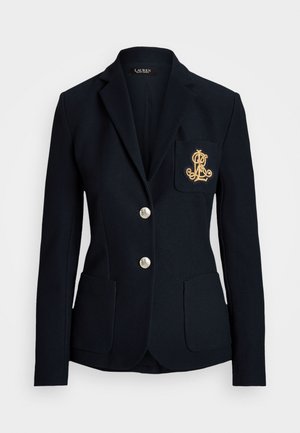Jūras spēku blazeris ar pielāgotu piegriezumu, zelta pogas, divas priekšējās kabatas un izšūts logotips kreisajā krūšu kabatā. Strukturēta auduma.