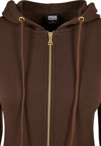 Sweat à capuche marron à fermeture éclair dorée, cordons de serrage et étiquette "Urban Classics" XS à l'intérieur du col.