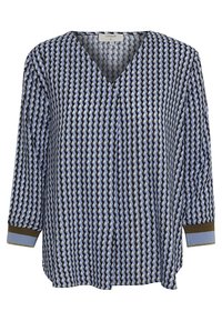 Blus med blå, svart och vit geometrisk mönster, V-hals och trekvartsärmar med blå och bruna muddar.