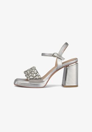 Silver high-heel sandal with block heel, ankle strap buckle, and front strap embellished with large clear rhinestones.