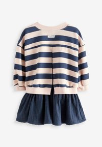Pull rayé rose et marine avec un col rond, une coupe décontractée, et une jupe peplum en tissu texturé marine.