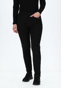 Zwarte stretchbroek met een smal silhouet, voorzien van voorzakken en een knoopsluiting. De stof is glad met een matte afwerking.