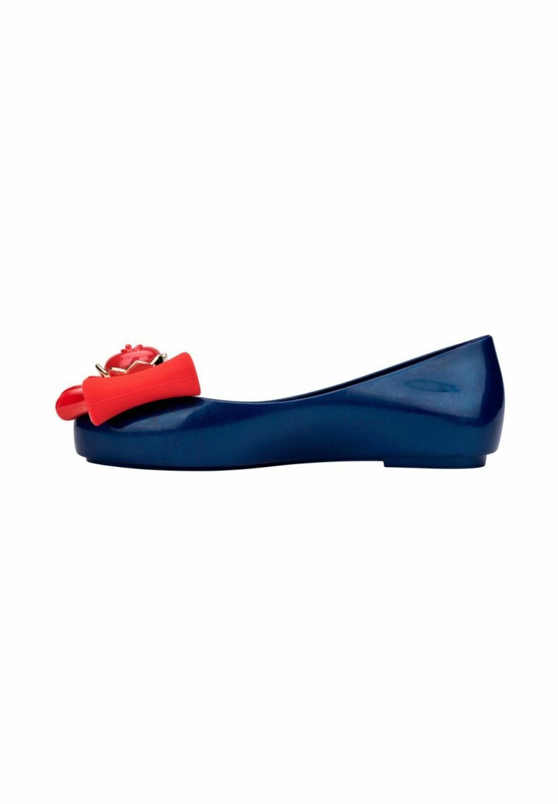 Navy blue flat shoe with a rounded toe, featuring a red decorative bow and flower accent. Smooth, shiny finish and minimal heel.