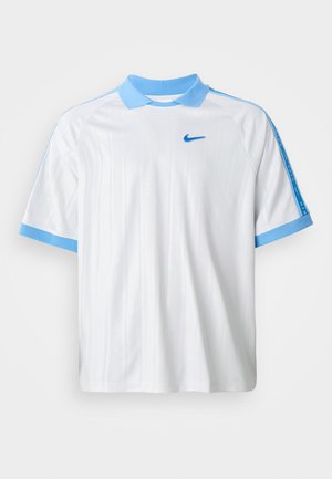 Bela športna majica Nike z svetlo modrim ovratnikom, robovi rokavov in črtami na ramenih, ki ima majhen modri Nike znak na prsih.