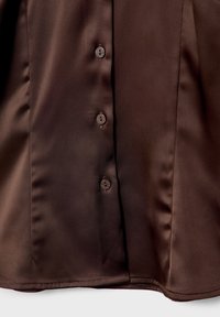 Brown satin blouse with a smooth texture, featuring six matching buttons down the front and a straight hemline.