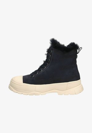 Navy Suede-Ankle Boots mit Kunstfellbesatz, weißer Gummi-Zehenkappe und dicker Sohle. Verfügt über metallene Ösen und eine Zuglasche an der Rückseite für ein einfaches Anziehen.