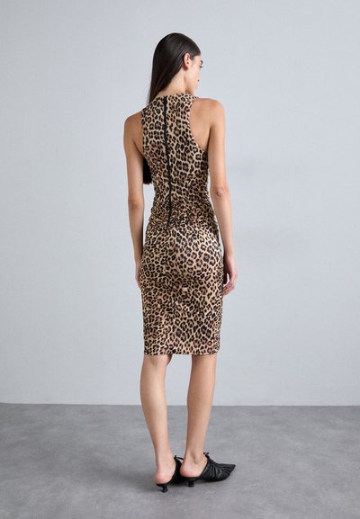 Brown leopard print bodycon dress with a high neck and back zipper, complemented by a ruched texture and shaped hem. Black footwear.
