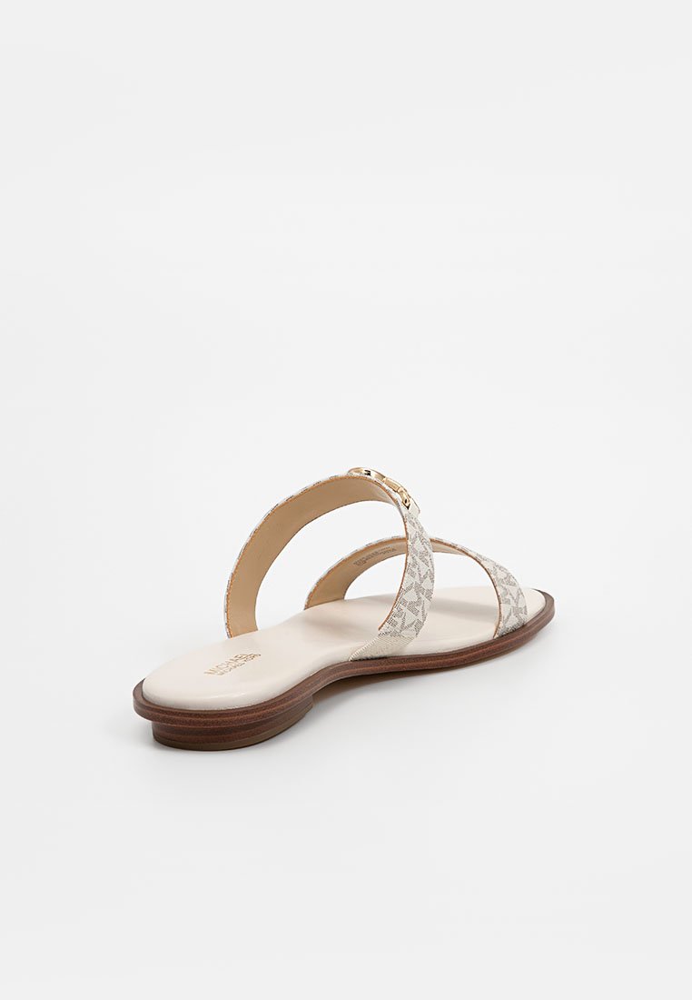 Sandali piatti beige chiaro con un design a due fasce, tessuto testurizzato e una suola liscia. La suola è realizzata in materiale marrone simile al legno.