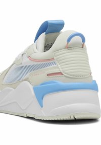 Vit och ljusgrå sneaker med blå och rosa accenter, med en texturerad häl, vadderad fotled och en dragflik för enkel påtagning.