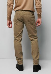 Spodnie sztruksowe w kolorze khaki o dopasowanym kroju, z dwoma tylnymi kieszeniami, teksturowaną tkaniną, zestawione z czarnymi botkami do kostki.