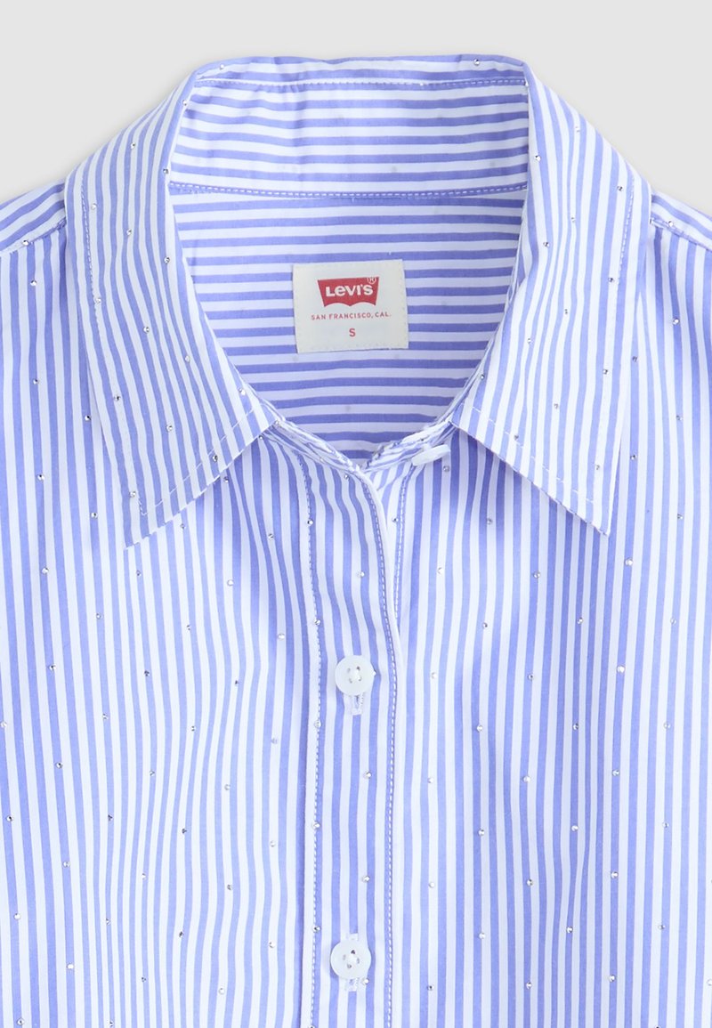 Chemise à rayures bleues et blanches avec de petites touches scintillantes, dotée d'un col standard et d'une étiquette Levi's à l'intérieur du col.