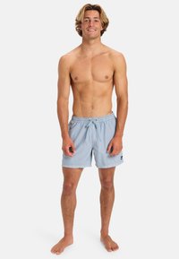 Světlomodré plavky s elastickým pasem a šňůrkou. Obsahují postranní nášivku s logem a mají volný střih. Měkká, strukturovaná tkanina.