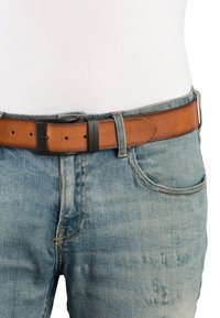 Ceinture en cuir marron avec une boucle en métal noir mat, dotée de plusieurs trous d'ajustement, assortie à un jean en denim bleu clair.