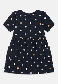 Marineblå bomullskjole med korte pufferm, med en utsvingt skjørt og lyse dots i lilla, oransje og krem. Inkluderer sidelommer.