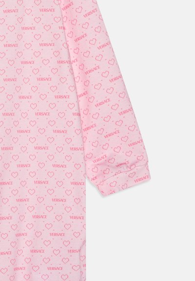 Pink long-sleeve shirt featuring an all-over heart pattern and "VERSACE" text in red, made from soft fabric with a comfortable fit.