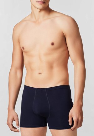 Boxer in cotone blu navy per uomo. Presenta una vestibilità aderente con cinturino elastico e cuciture a contrasto, senza motivi o grafiche.