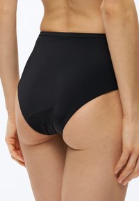 Čierne bikiny s vysokým pásom zo hladkej látky, so švovým dizajnom a minimálnym elastickým pásom pre pohodlie.