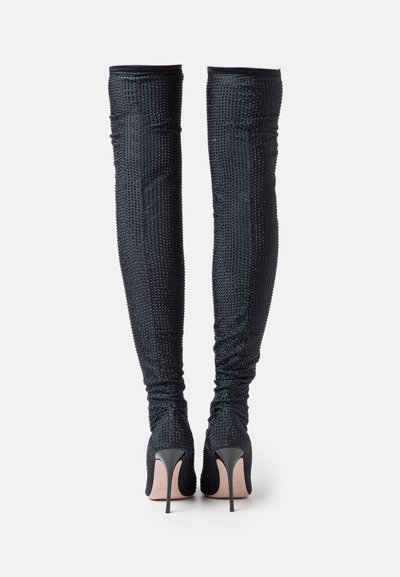 Black, thigh-high stiletto boots with textured fabric and metallic embellishments, featuring a fitted design and pointed heels.