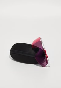 Solsken med gradient lila till rosa linser, klara bågar, vilande på ett svart hårt skalfodral med dragkedjestängning.