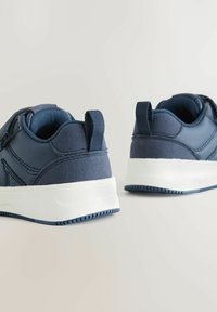 Granatowe sneakersy z teksturowanym wykończeniem, wyłożonymi kołnierzami, z rzepami i białą gumową podeszwą z rowkami zapewniającymi przyczepność.