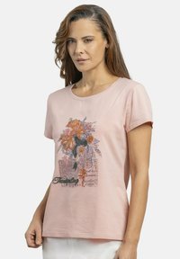 Camiseta de algodón rosa con un diseño de bordado floral en naranja y púrpura en la parte frontal, con mangas cortas y un cuello redondo.