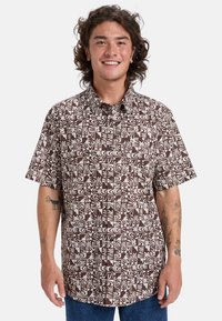 Korte mouwen shirt met een bruin en wit geometrisch patroon; heeft een button-down kraag en een borstzak, gemaakt van lichtgewicht stof.