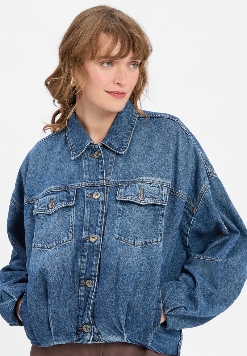 Leren spijkerjack in lichtblauw met een losse pasvorm, knoopsluiting, twee borstzakken met kleppen en contrasterende stikseldetails.