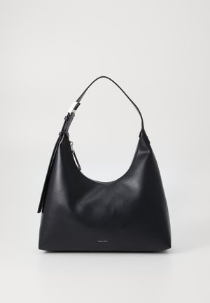 Bolso de hombro de cuero negro con cierre de cremallera y correa delgada, con pequeño logo de Calvin Klein en el centro inferior.