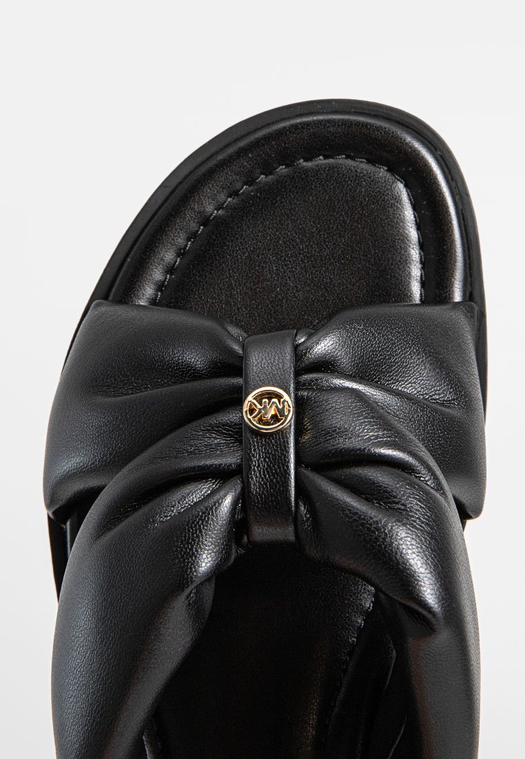 Sandale en cuir noir avec un design de nœud sur le devant, détails en métal doré et surface lisse.