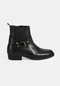 Bottines en cuir noir avec une finition lisse, dotées d'une sangle décorative avec quincaillerie dorée, d'un léger talon et de panneaux élastiques sur les côtés.