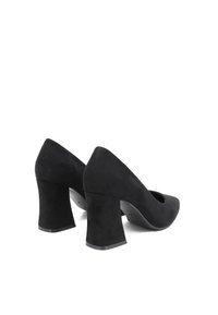 Scarpe nere in suede con tacco alto e punta affusolata, con tacco a blocco. Texture liscia senza motivi, con un design a ritaglio sui lati.