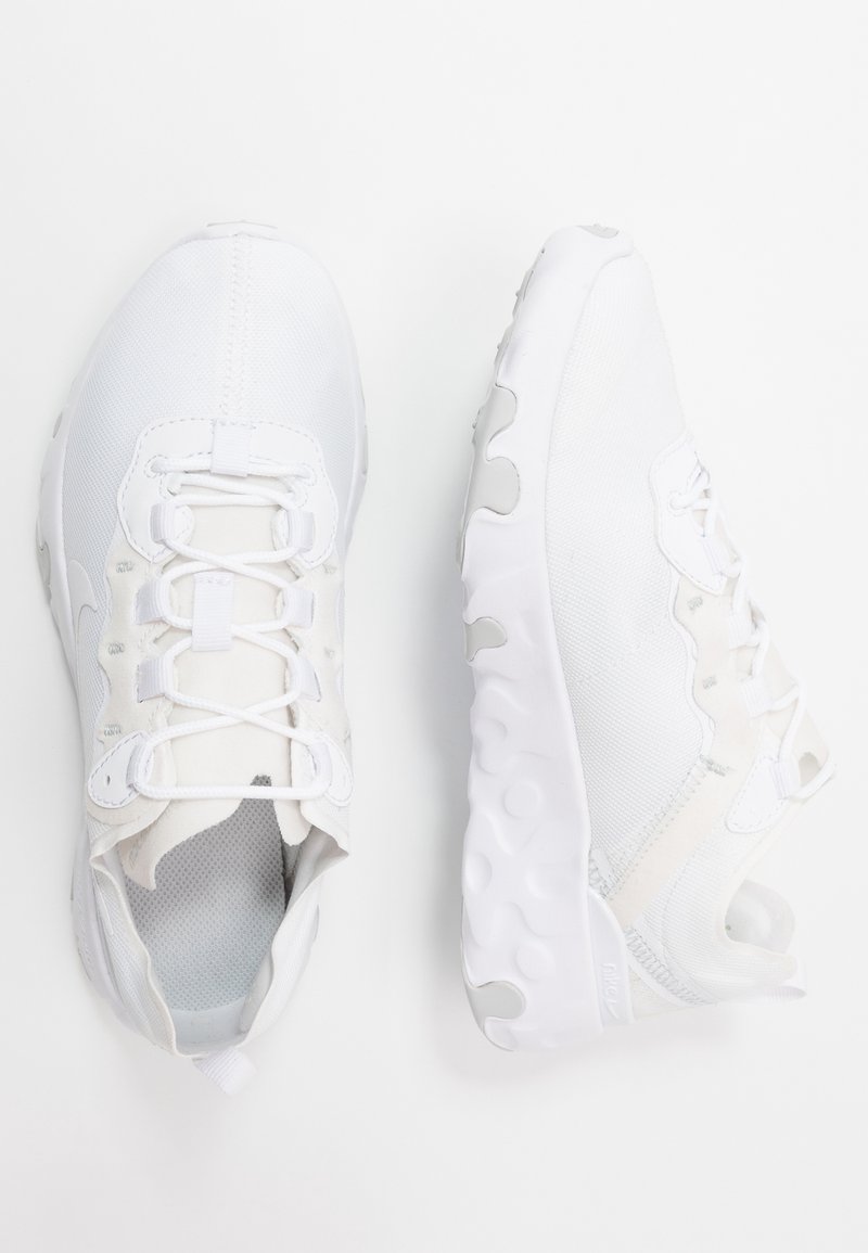 Paire de baskets blanches vues de dessus et de côté, avec des semelles texturées et des dessus en mesh lacés sur fond blanc.