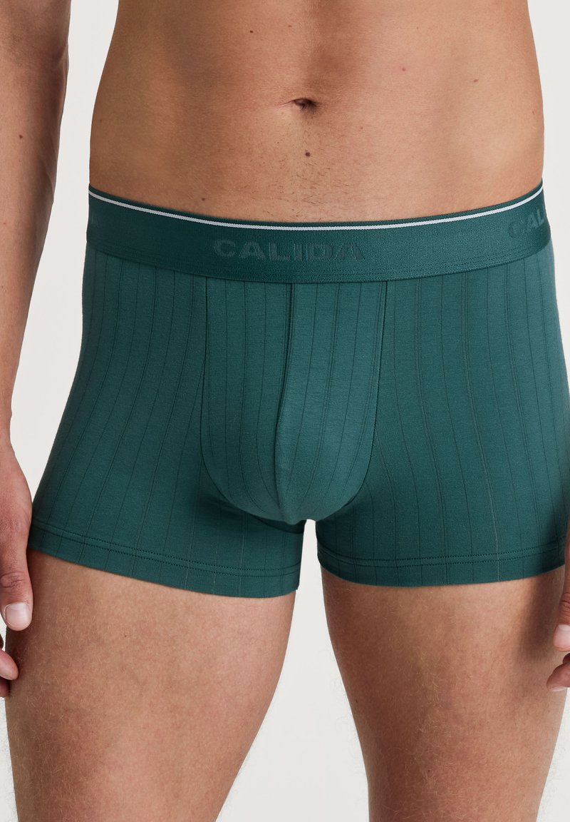 Groene, ribbelige boxershorts met een aansluitende pasvorm. Voorzien van een contrasterende tailleband met "CALIDA" branding en elastiek voor comfort.