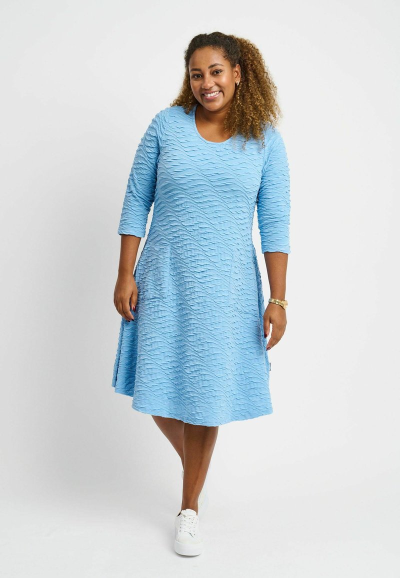 Blaues, strukturiertes Kleid mit einem wellenförmigen Muster, rundem Ausschnitt und Dreiviertelärmeln. A-Linienform mit einem mittellangen Saum.