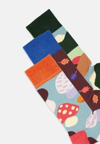 Bunte gemusterte Socken mit blauen, grünen, orangefarbenen und dunkelroten Abschnitten sowie Blatt- und Pilzmotiven auf einem hellblauen Hintergrund.