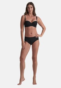 Set di bikini nero composto da un top in stile balconcino con spalline sottili e slip a vita alta coordinati, che mettono in mostra una texture liscia e opaca.