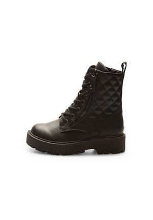 Bottes de combat noires avec une tige synthétique matelassée, un laçage à l'avant, une fermeture éclair sur le côté et une semelle en caoutchouc épaisse. Accentuées par des œillets en métal.