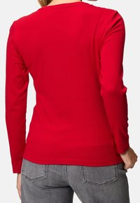 Rotes Langarm-T-Shirt, Rundhalsausschnitt, figurbetontes Design, aus glattem Baumwollgewebe, mit einer einfarbigen Textur und ohne sichtbare Muster.