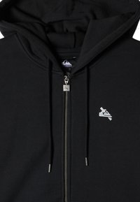 Black zip-up hoodie with drawstrings, featuring a silver logo on the chest and a soft, textured fabric. Hooded design visible.
