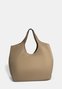 Beige hobo-tas met een gestructureerd leermateriaal, afgeronde vorm en een grote uitgesneden handgreep voor gemakkelijk dragen.
