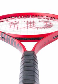 Rode tennisracket met een gestructureerde zwarte grip, voorzien van een brede ovale kop en witte snaren. Opvallend logo-ontwerp op het frame.