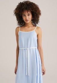 Hele sinise triibulise kleidi õhukeste rihmadega, ümmargune kaelus ja seotud vöödetail. Valmistatud pehmest kangast, millel on mugav lõige.