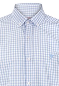 Camisa a cuadros en azul claro y blanco, con cuello abotonado, botones en la parte delantera y un pequeño logo de un pájaro azul en el lado izquierdo del pecho.