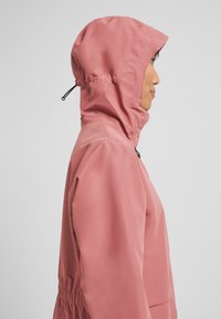 Roze waterdichte jas met een aansluitende capuchon, elastische taille en zijzakken. Stijve textuur met een minimalistisch design.